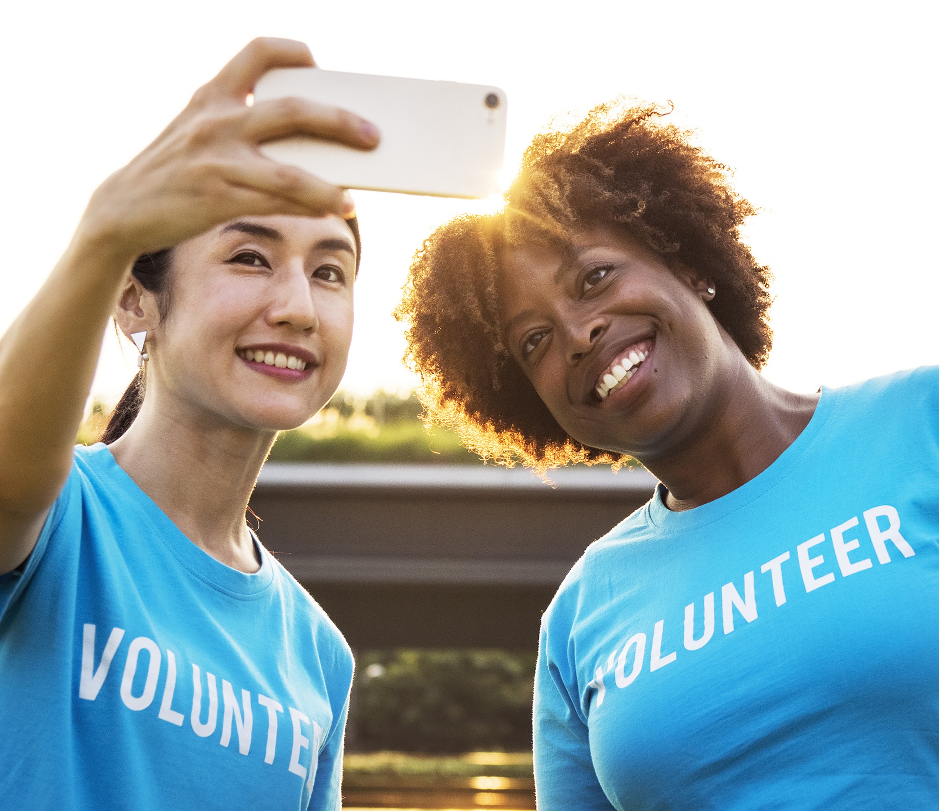 Two women with volunteer shirts on taking a selfie, published to: "Non-Profit Social Media Ideas: 3 Organizations Who Are Killing It"