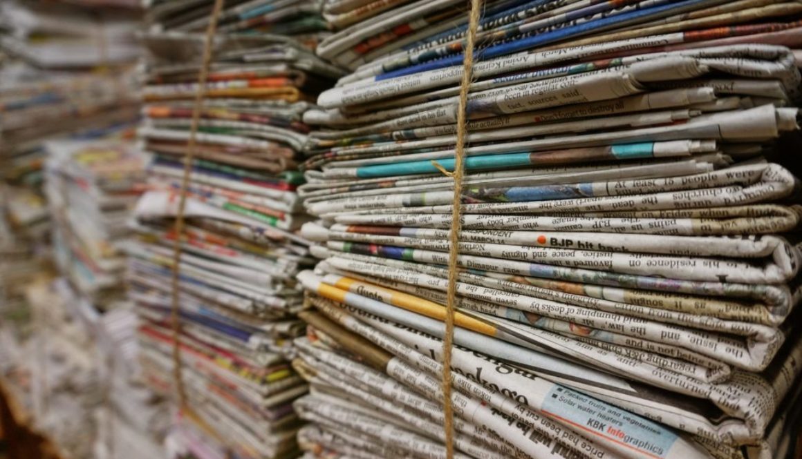 A photo of newspapers bundled together, published to 