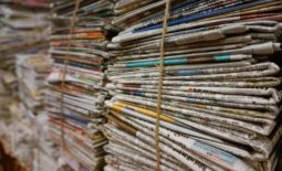 A photo of newspapers bundled together, published to 
